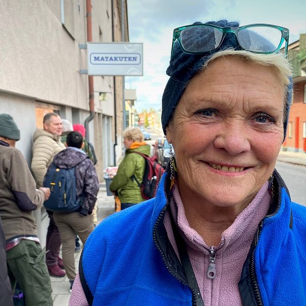 En stående hon leende kvinna (Eva Huss) vid Matakutens kö i Gävle.