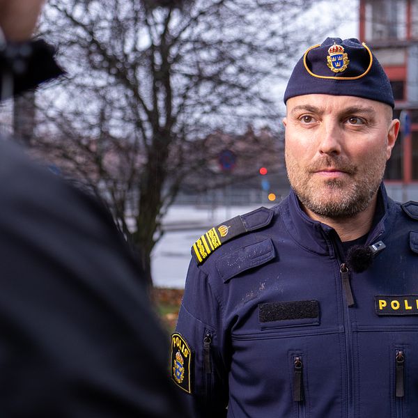 Temo Allenbäck, tillförordnad lokalområdeschef på Gävleborgspolisen, iklädd polisuniform, blir intervjuad utomhus om våldet i Gävleområdet.