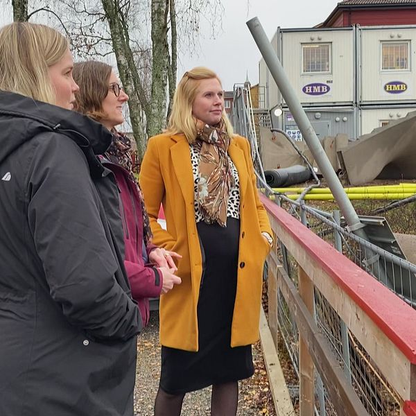 tre kvinnor som ingår i Dalauppropet, står vid en byggarbetsplats i Falun och kollar på när de bygger.