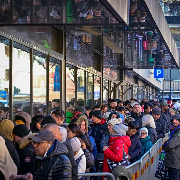 En bred och lång kö av människor står utanför Migrationsverket i Sundbyberg och väntar på att få komma in.