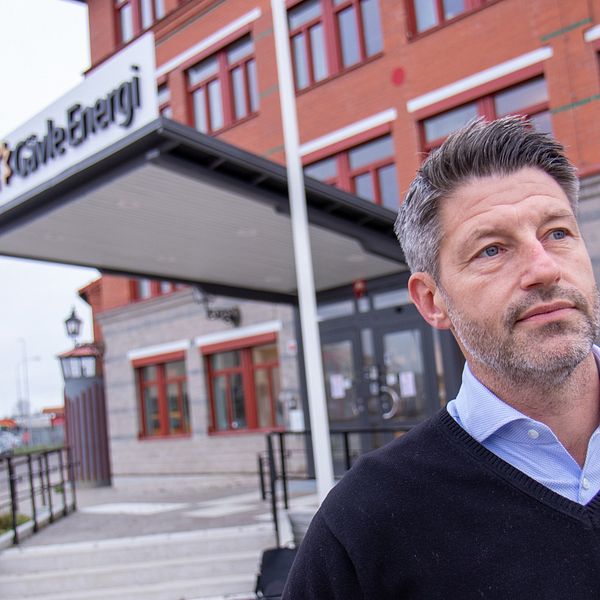 Bilden visar Anton Holton, vd Gävle Energisystem, när han står framför kontoret till Gävle Energi. Han har på sig en svart tröja och har kort grått hår.