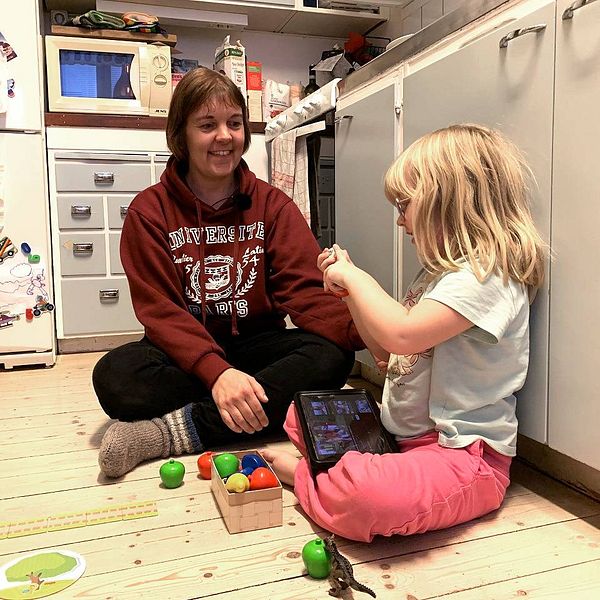 Niina Sallmén och dottern Edit sitter och leker på golvet.