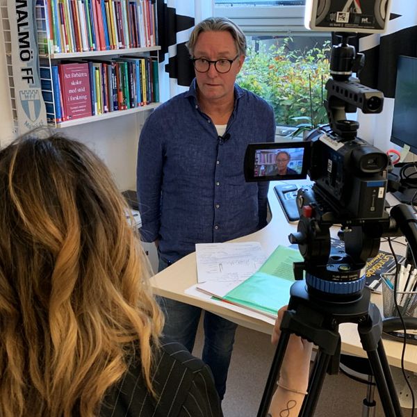 Intervju inspelas i ett kontor, kamera och utrustning synliga.