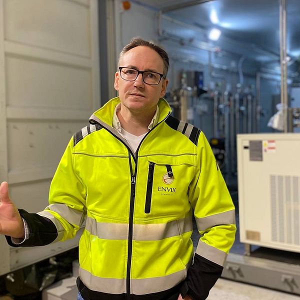 Daniel Ragnvaldsson från företaget Envix förklarar hur de renar läkemedel ur avloppsvattnet i Strömsund. Daniel är klädd i gul varseljacka och står framför en container där dörrarna är öppna och man ser teknisk utrustning i containern.