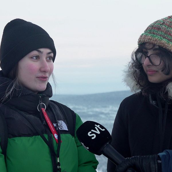 en tjej i mössa och dunjacka intervjuas, utsikt över vinterlandskap bakom