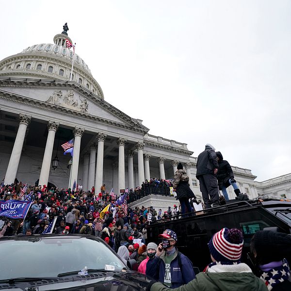 USA:s kongress Kapitolium med folkmassor utanför som försöker ta sig in i byggnaden.