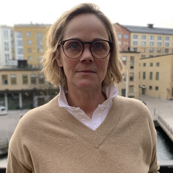 Anna Selander, tf kommundirektör står vid byggnader i Norrköping.