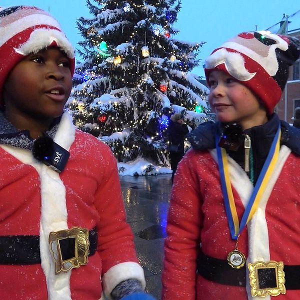 två småpojkar i tomtekläder framför julgranen på torget i Umeå