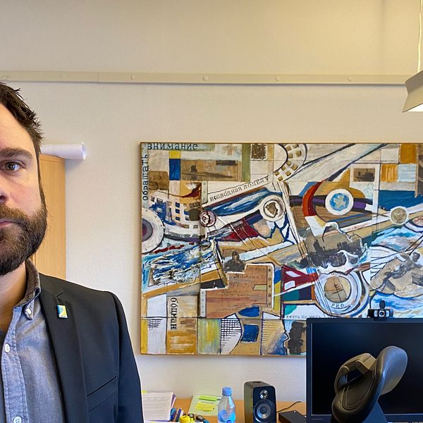Bild på man med kostym i ett kontor med en färgglad tavla. Mannen heter Daniel Johansson och är socialchef i Laholm. Han berättar om läget med det ekonomiska biståndet till barnfamiljer som blivit färre trots inflation.