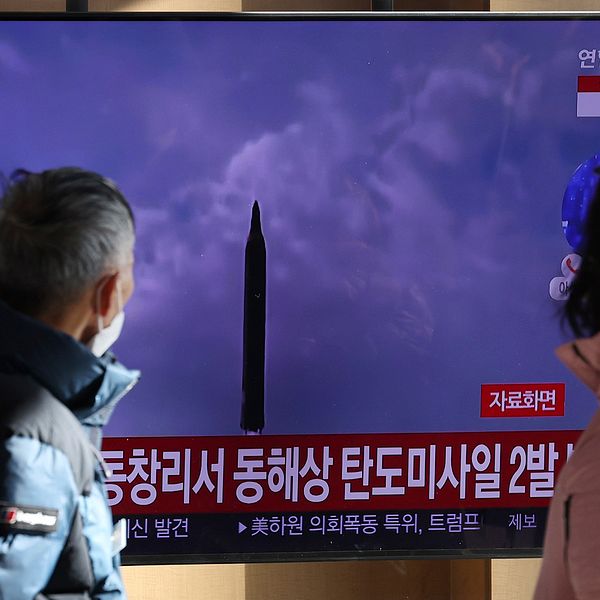 Människor tittar på en tv med bilder på de senaste  avfyrningarna från Nordkorea.