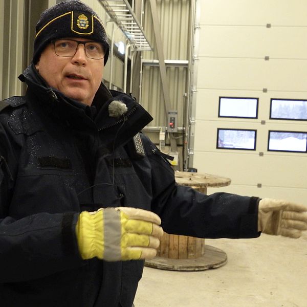 Magnus Holmqvist, gruppchef för trafikpolisen i Västerbotten står inne i den nya kontrollplatsen. Han är iklädd polisjacka och mössa som båda har emblem. På händerna har han ett par varselhandskar i gult och reflextyg.
