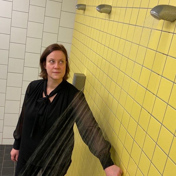 Miljöinspektör Eva Jansson vid Sundbybergs kommun startar en av duscharna i simhallens omklädningsrum.