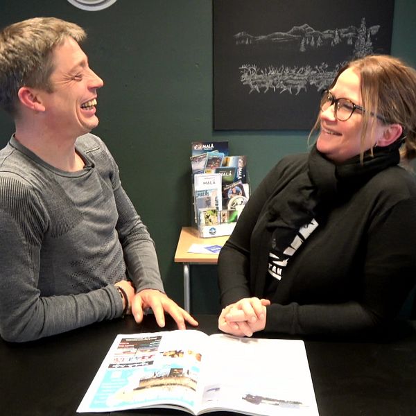 Johann Schatton, produktutvecklingschef hos FlyCar samt Angelica Edlund, hotellchef på Tjamstan, står mittemot varandra vid ett bord och skrattar.