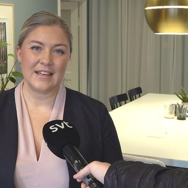 Mäklare som står och blir intervjuad