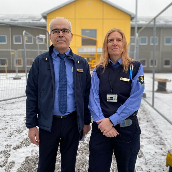 Mohamad Mehanna och Åsa Bergström framför kriminalvårdsanstalten Rödjans nya tvåvåningsanstaltsbyggnad, som går i gult och grått.