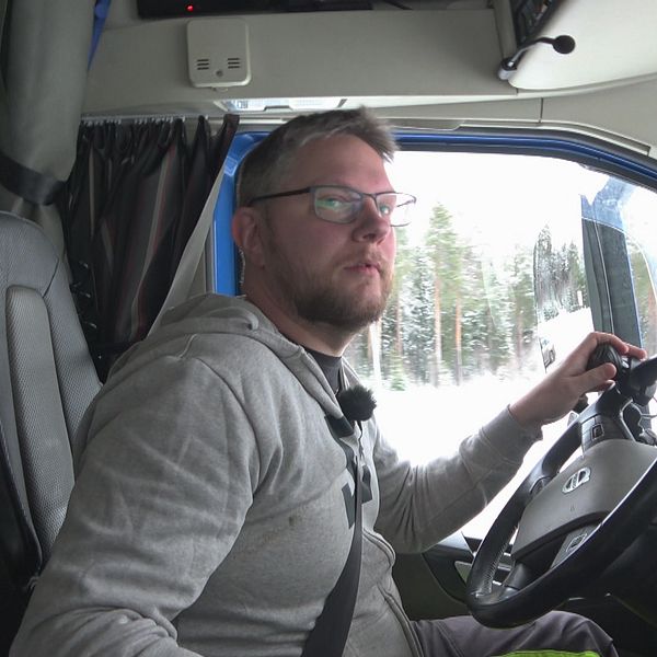 Lastbilschauffören Andreas Nyqvist sitter i sin hytt. Han har ljust hår, skägg och glasögon. Vänster hand är placerad på ratten och blicken är fäst åt höger. Det är ljust ute och i bakgrunden syns barrskog.