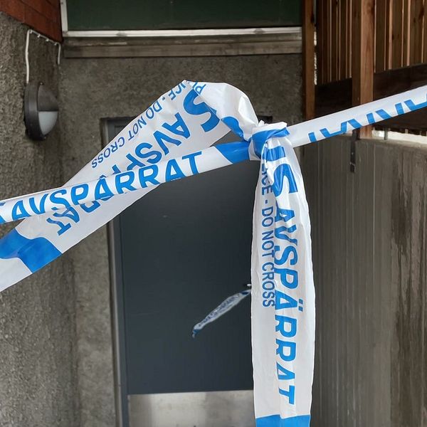 Bild på polisens avspärrningsband framför en ingång till ett bostadshus, i samband med polisens stora insats i Sundsvall.
