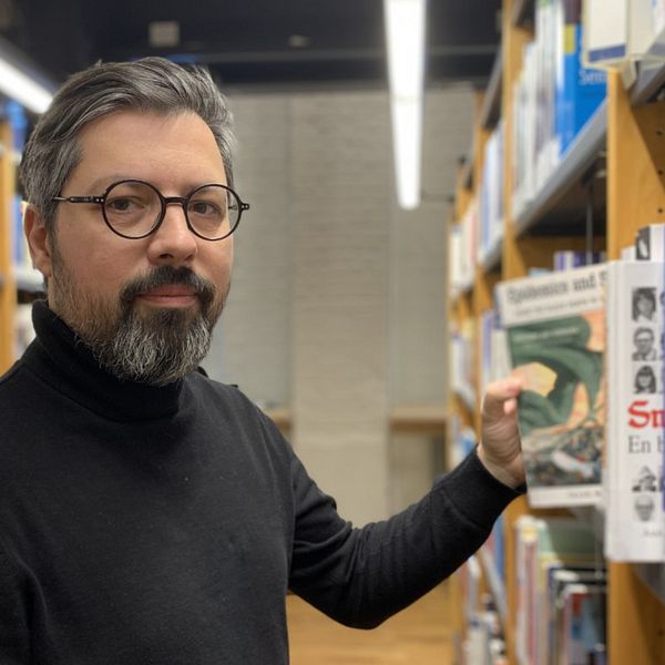 Radu Dino, universitetslektor i historia på Högskolan i Jönköping, letar efter böcker i högskolebilioteket.