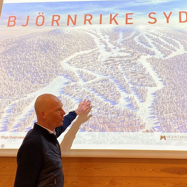 Mats Svensson, styrelseordförande i Björnrike Syd, berättar om planerna som tagit ny fart. Mats, en skallig man, står framför en bild som visar pistområdet