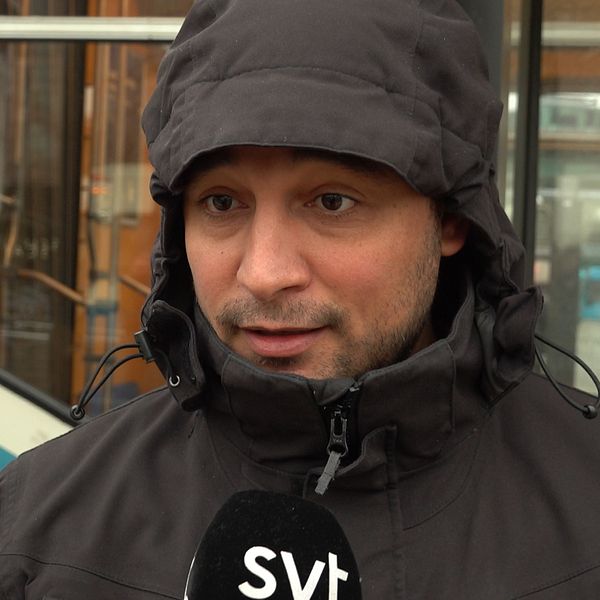 Adil El Harti blir intervjuad av SVT om biljettkontrollanter på Västtrafiks fordon, bakom honom skymtar en spårvagn.