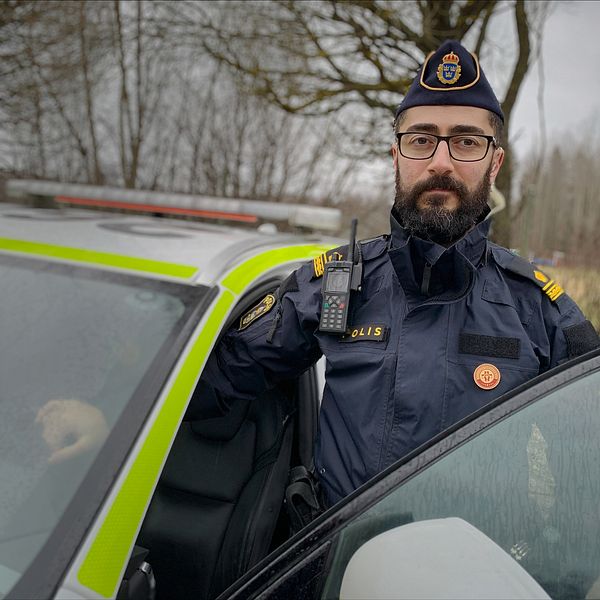 Roj Darwich, skyddsombud och utredare vid polisen i Gävleborg står vid en polisbil.