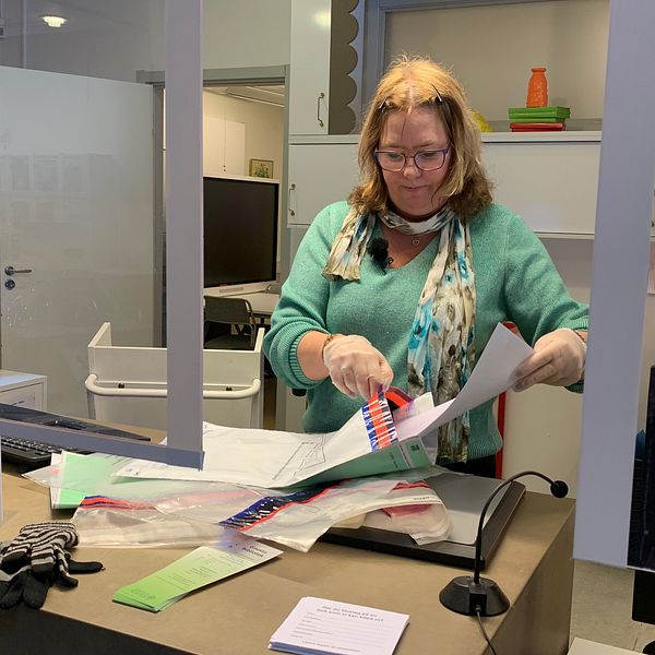 Kristina Karlsson, enhetschef på biblioteket i Gnesta, stoppar in ett kuvert i ett säkert plastemballage så att det kan skickas iväg för kontroll.