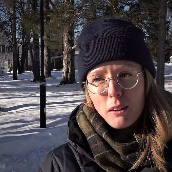 Linnea Swedenmark står iklädd vinterkläder med snö i bakgrunden och berättar om sin protest mot minskade pengar till Jämtlands naturreservat.