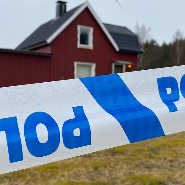 Polisavspärrning framför ett rött trähus.