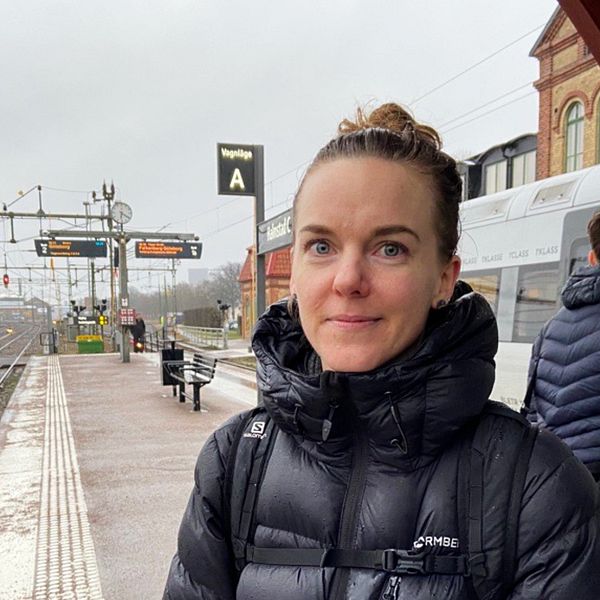 Pendlaren Karin Lövgren står framför ett tåg på Halmstad station.