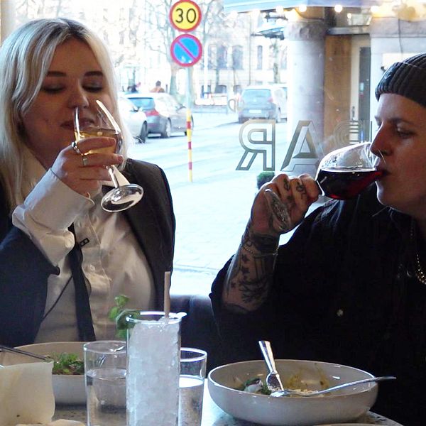 Ett par sitter på en restaurang och dricker vin