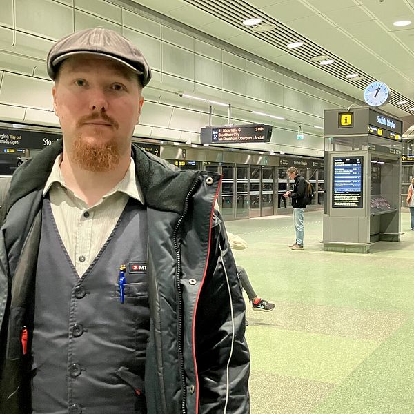 Anton Pajaujis, står i MTR-uniform på Stockholm city pendeltågsstation.