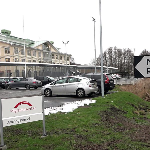 Exteriör på Migrationsverkets förvar i Mlöndal. På bilden syns bilar parkerade framför huvudbyggnaden, snö och en skylt.