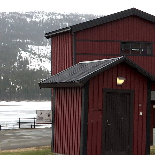Ett rött hus med svarta knutar och svart tak står vid Åresjön. Bilden visar reningsverket i Vik.