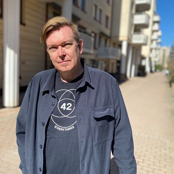 Erik von Stedingk, blont hår och blå tröja, står utanför bostadsrättsföreningen Smyrnas hus på Gärdet.