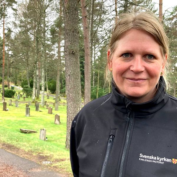 Elna Forsberg är kyrkogårdschef på i Karlstads pastorat står i halvkroppsbild på en kyrkogård. Hon ler mot kameran.