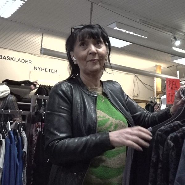 Aurelia Jensen står med svart läderjacka och grön tröja i sin klädbutik i Hammarstrand.