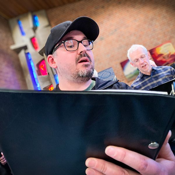 Peter Wängelin, förstatenor, sjunger körsång med nothäfte i handen.