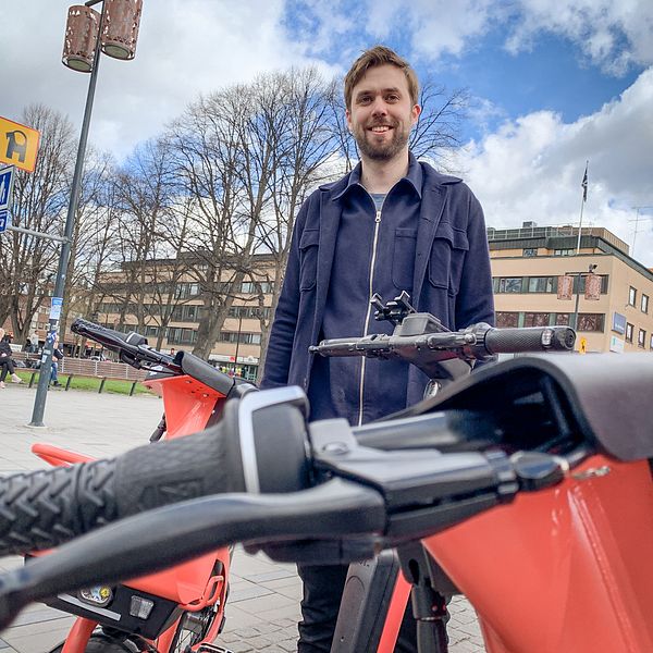 Viktor Olejnik, Sverigechef på Voi, framför flera cyklar på Rådhustorget i Gävle.