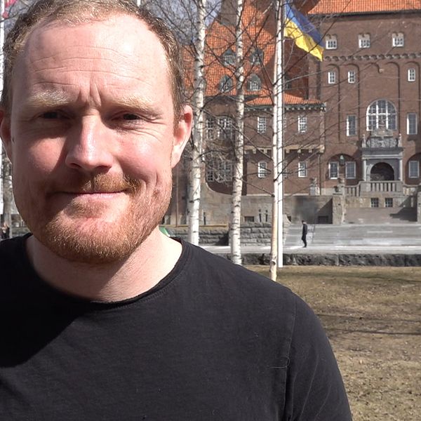 Niklas Daoson (S), kommunalråd i Östersund i svart t-shirt framför rådhuset har ändrat sig och vill ha kvar parkeringar i centrum.