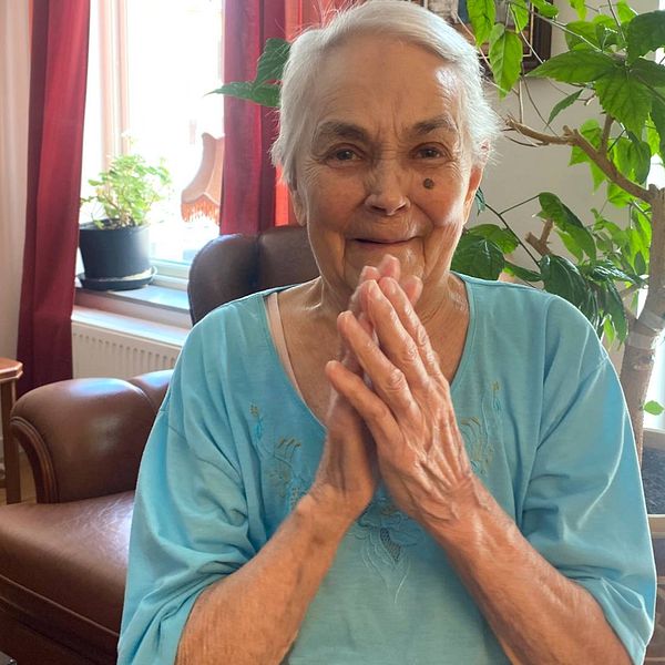 Bild på 91-åriga Leila som ler och håller händerna upp i en applåd.