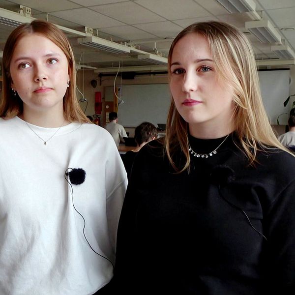 Eleverna Elin Sundström och Heidi Nilsson står i ett klassrum.