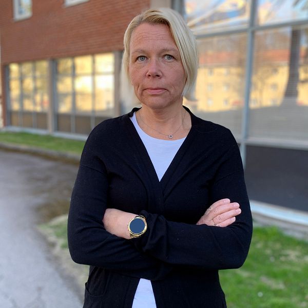 Fältsocionomen Malin Åström, en kvinna i medelåldern med blont hår, står utomhus med armarna i kors.
