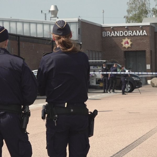 Två poliser vaktar avspärrningsbanden vid en brottsplats i Helsingborg. I bakgrunden syns andra poliser som fotograferar något.