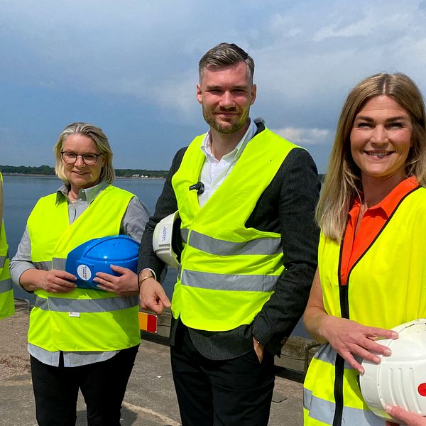 Kommunstyrelsens ordförande Stefan Pålsson (S) står tillsammans med tre kvinnor i varselväst vid vattnet.