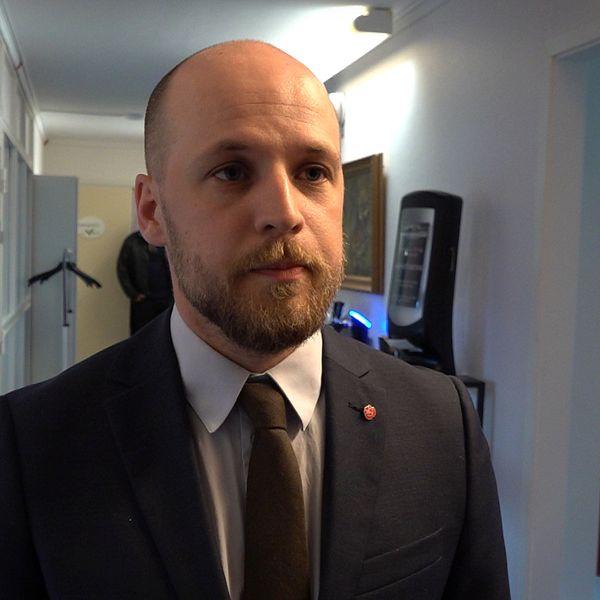 Anton Hammar (S) oppostionsråd, en man med kort skägg står i korridor med kostym och slips.