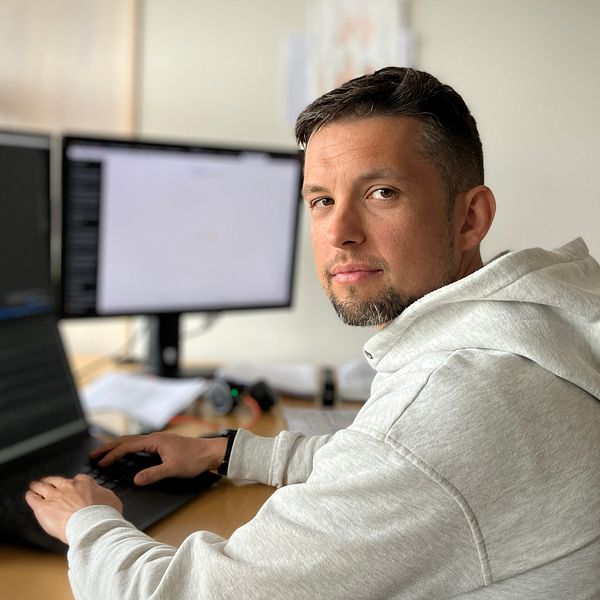 Felix Dobslaw, forskare på MIUN sitter framför dataskärmar och tittar in i kameran.