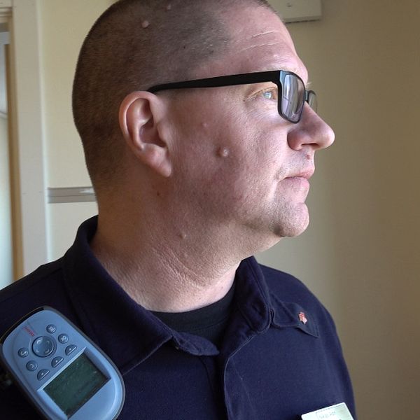 En kriminalvårdare som tittar mot ett fönster.