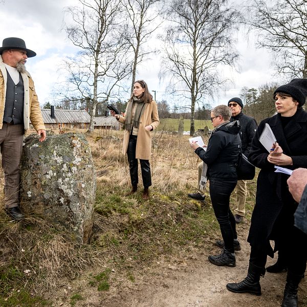 Vikingabyns ägare Oddvar Lönnerkrantz vid en av stenarna på Vätteryds gravfält. Han gestikulerar och förklarar för tingsrättens ledamöter som har syn på plats. Bilden är tagen under rättegången i Hässleholms tingsrätt.