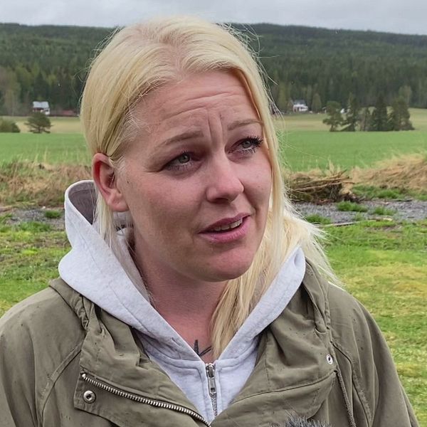 På bilden syns Tove Gidgård, som är timvikarie i Sollefteå kommun. Hon står utomhus och i bakgrunden syns grönt gräs och till höger syns ett rött hus. Hon tittar inte in i kameran. Hon har en grön jacka på sig och en grå hoodie och blont hår.