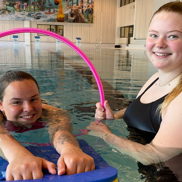 Två tjejer som är simlärare i en bassäng